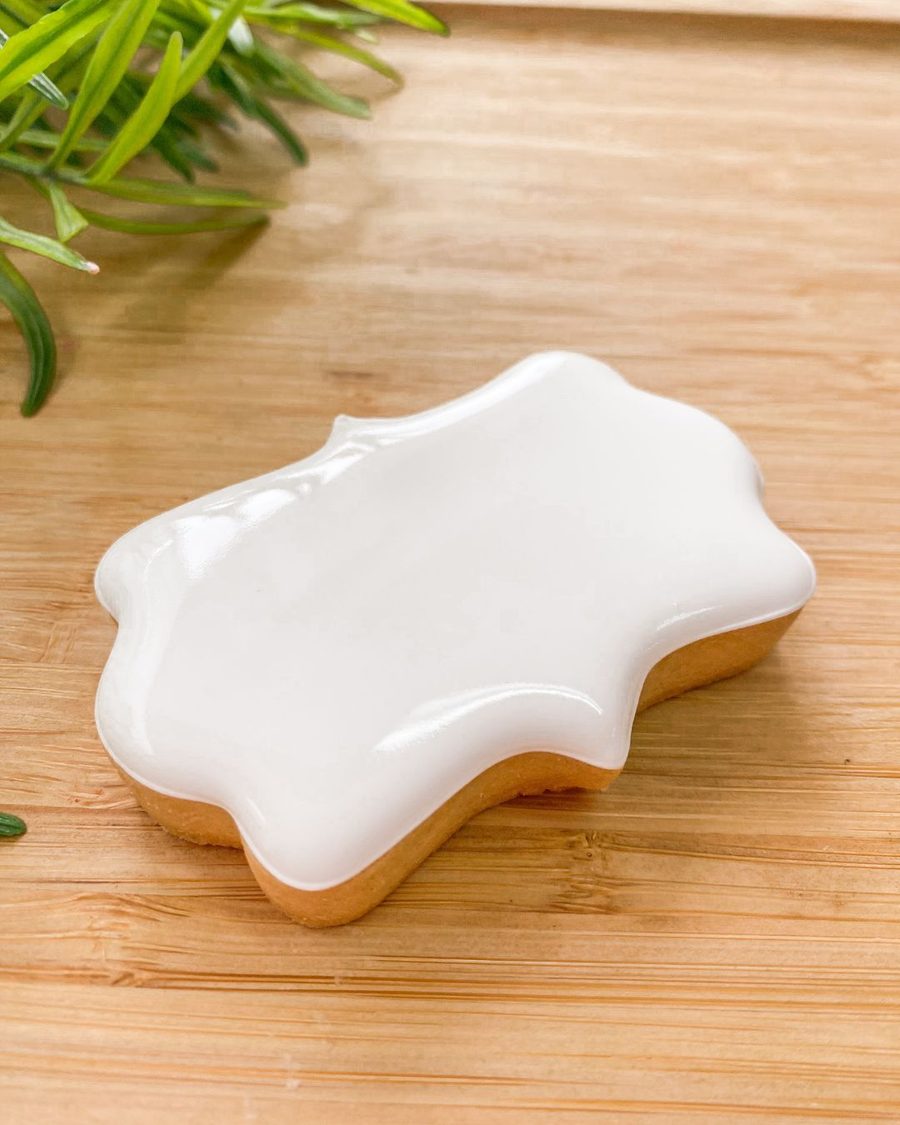 Biscoito preenchido com glacê real branco, liso e brilhante