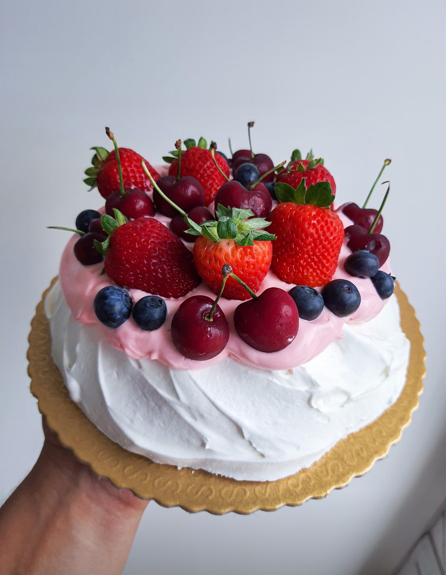 Pavlova coberta de morangos, cerejas e mirtilos